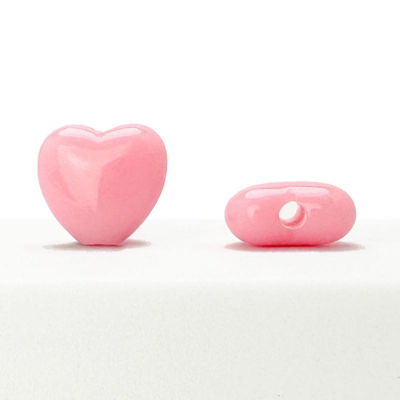 Assorted 10mm heart-shaped pink acrylic beads on a white background