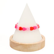 Assorted 8mm heart-shaped acrylic beads in red and pink colors on a white cone on a white background