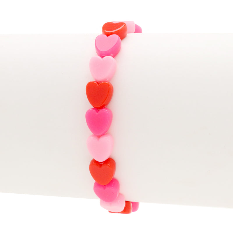 Assorted 8mm heart-shaped acrylic beads in red and pink colors on a white bracelet mandrel on a white background